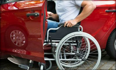 Immagine: foto di una persona con disabilità motoria che sale in macchina