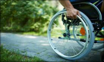 Immagine: foto di ruota di sedia a ruote in movimento su un marciapiede
