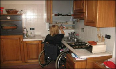 Immagine: foto di una persona con disabilità in carrozzina in una cucina accessibile