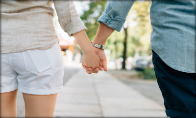 Immagine: foto di due persone di spalle che per mano camminano assieme