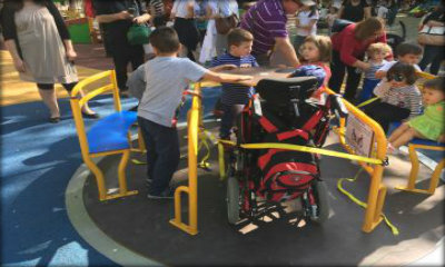 Immagine: bambini che giocano su un girello accessibile