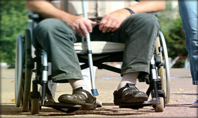 Immagine: foto primopiano gambe di una persona su sedia a rotelle